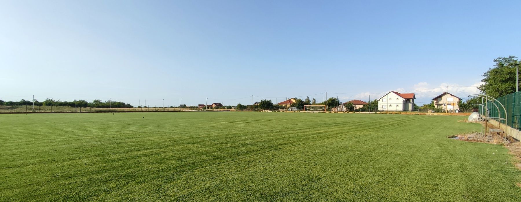 The mown pitch with goal and dugout, June 2025
